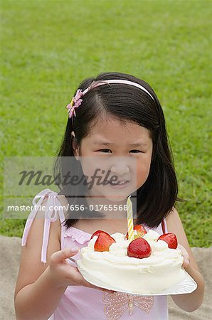 Jeune fille tenant le gâteau avec une bougie