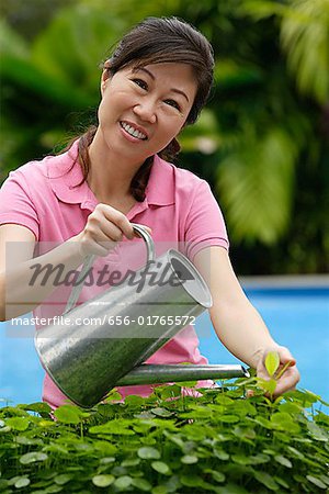 Woman with watering can, watering plants