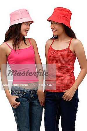 two young women wearing red and pink, looking at each other