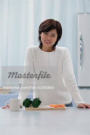 Femme dans la cuisine, souriant à la caméra