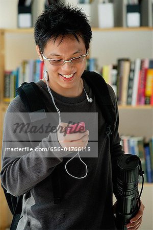 A young man listens to music in the library