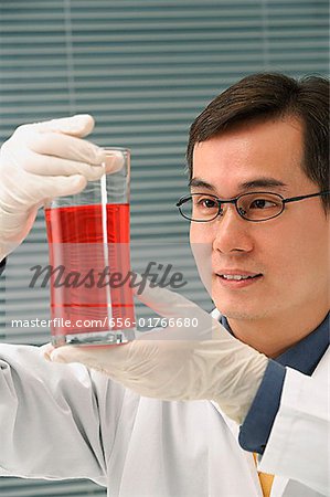 Scientist examining container of fluid