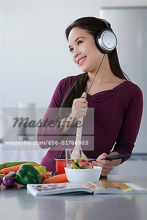 Jeune femme cuisine tout en écoutant de la musique
