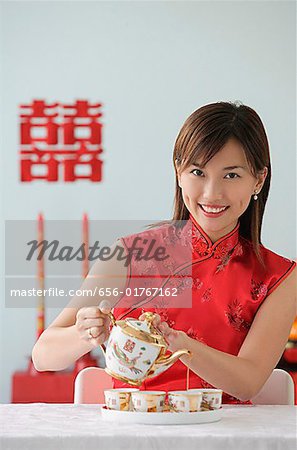 Young woman performing tea ceremony and smiling at camera