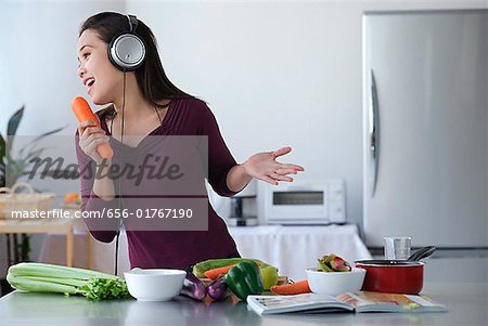 Young woman singing into carrot
