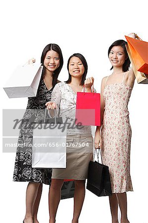 Three young women carrying shopping bags