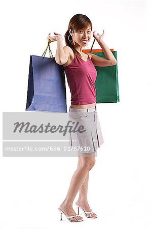 Woman standing, carrying shopping bags