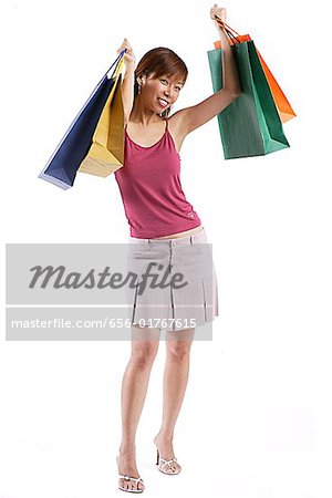 Woman standing, raising shopping bags