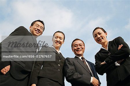 Businessmen and businesswomen looking down at camera, smiling