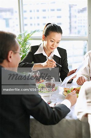 Executives looking at documents over lunch