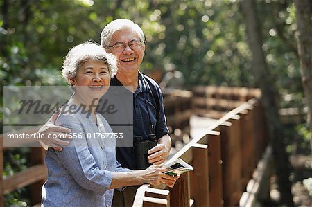 Couple d'âge mûr côte à côte, souriant, en regardant la caméra
