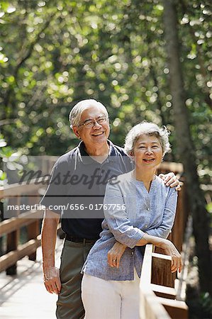 Mature couple standing, smiling, looking at camera