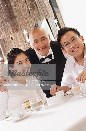 Waiter and customers at restaurant, looking at camera, portrait