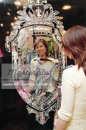 Femme dans le magasin de vêtements, tenue vestimentaire, en regardant le miroir