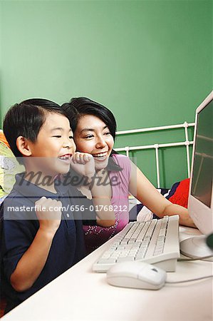 Mother and son looking at computer, smiling