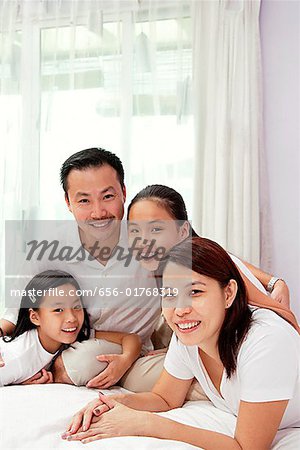 Famille de quatre personnes en souriant à la caméra