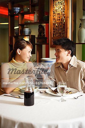 Couple toasting with wine glasses in Chinese restaurant