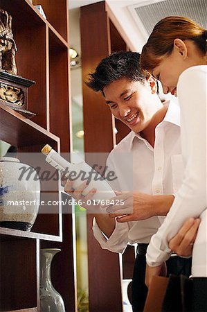 Couple standing weiter zur Anzeige in Antiquitätengeschäft, Blick auf die Flasche