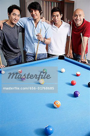 Männer stehen um Pool-Tisch