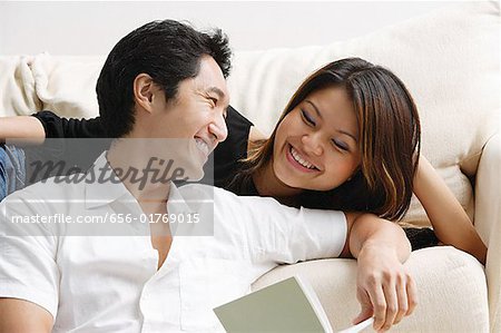 Couple looking at each other, man holding book