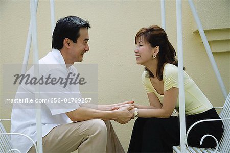 Paar, sitzen auf der Schaukel, einander betrachten