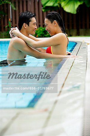 Couple en piscine, embrassant