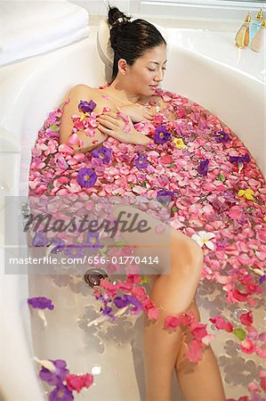 Femme dans la baignoire, entourée de fleurs