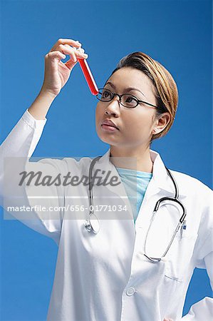Arzt betrachten Reagenzglas mit roter Flüssigkeit gefüllt