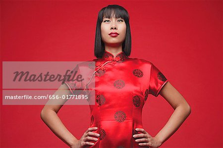 Femme portant cheongsam, mains sur les hanches