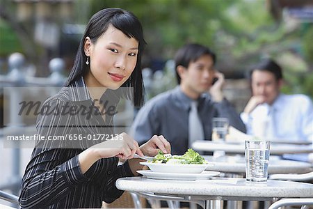 Geschäftsleute auf der Hotelterrasse, konzentrieren sich auf die Frau im Vordergrund, Blick in die Kamera