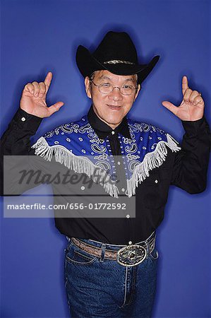 Senior homme habillé en costume de cow-boy, faisant signe de la main