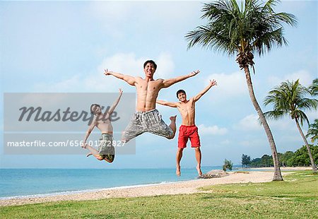 Three men jumping in air, arms outstretched