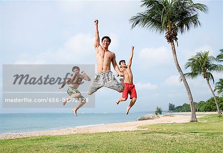 Drei Männer springen in der Luft, Blick in die Kamera