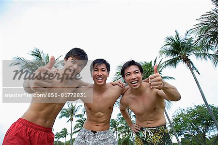 Three men with arms around each other, smiling at camera