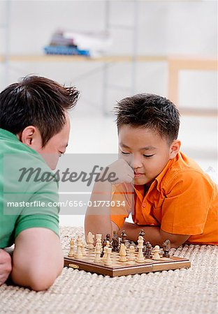 Father and son at home, playing chess
