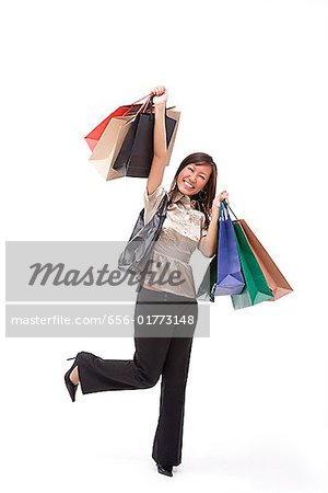 Woman carrying shopping bags, arms outstretched