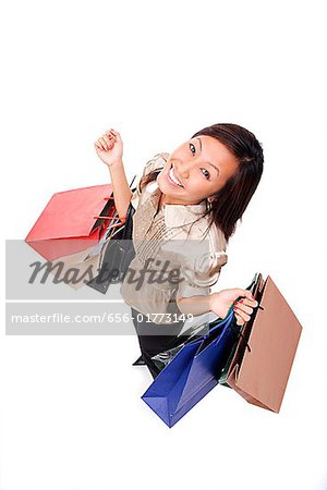 Woman carrying shopping bags, looking up at camera