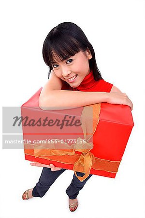 Jeune femme holding big red gift box, portrait