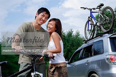 Mann auf dem Fahrrad, Frau stand neben ihm, Blick in die Kamera