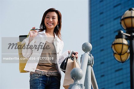 Femme transportant des sacs à provisions, souriant