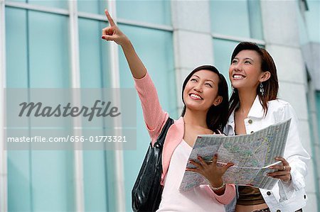 Two women with map, looking up