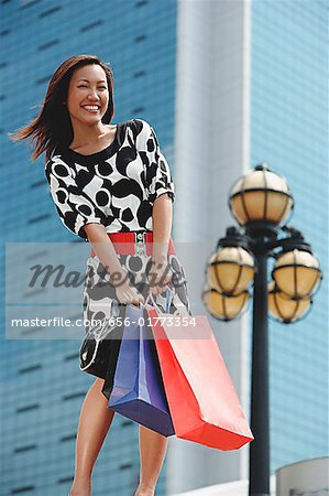 Woman carrying shopping bags, smiling