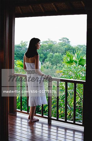 Jeune femme debout sur le balcon