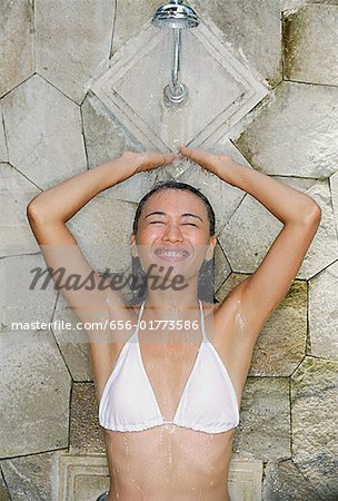 Jeune femme en bikini blanc, prendre une douche