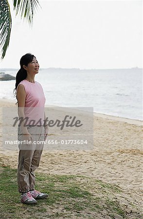 Woman standing on beach, smiling