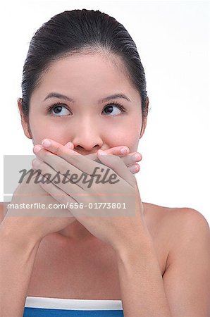 Jeune femme avec les mains sur la bouche