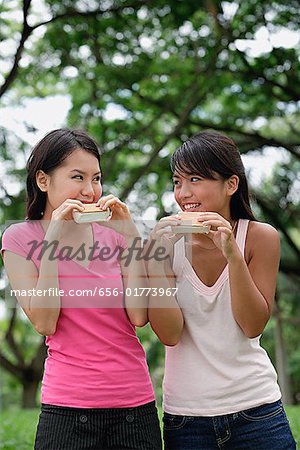 Two women eating ice cream, looking at each other