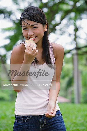 Young woman outdoors, eating ice cream