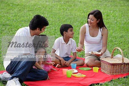 A family have a picnic together in the park