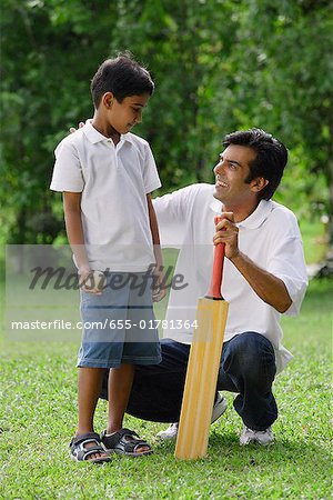Un père et son fils jouent au cricket ensemble
